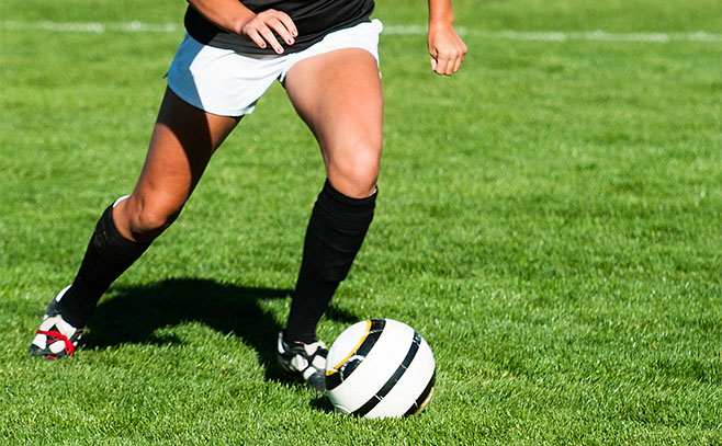 Soccer player running on green grass